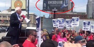 Bernie Sanders Ralley in Front of a "Knocked Loose" Billboard