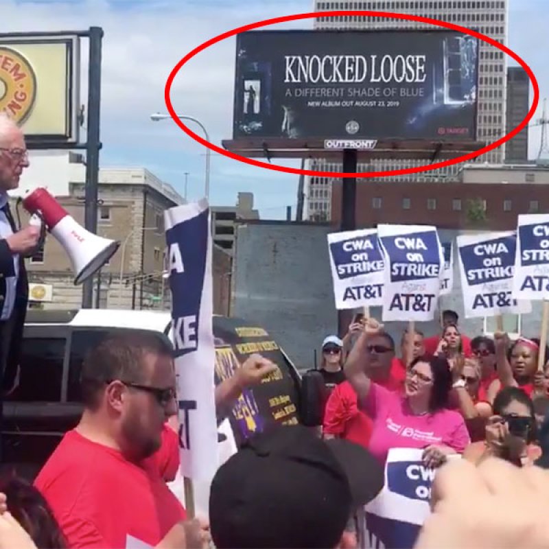 Bernie Sanders Ralley in Front of a "Knocked Loose" Billboard